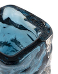Close-up of the Hendrick vase by The Import Collection—a square-shaped blue glass vase with wavy textured sides and a glossy finish. This elegant decorative piece is shown isolated on a white background.