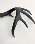 Gilded antler accent with four prongs on light wood, by Faire, natural elegance for home decor.