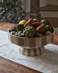 Botera Footed Bowl by Accent Decor styled on a wooden table with artichokes, pears, and potatoes.