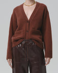 Woman modeling a slouchy cardigan sweater by Citizens of Humanity, styled with leather pants and gold necklace.