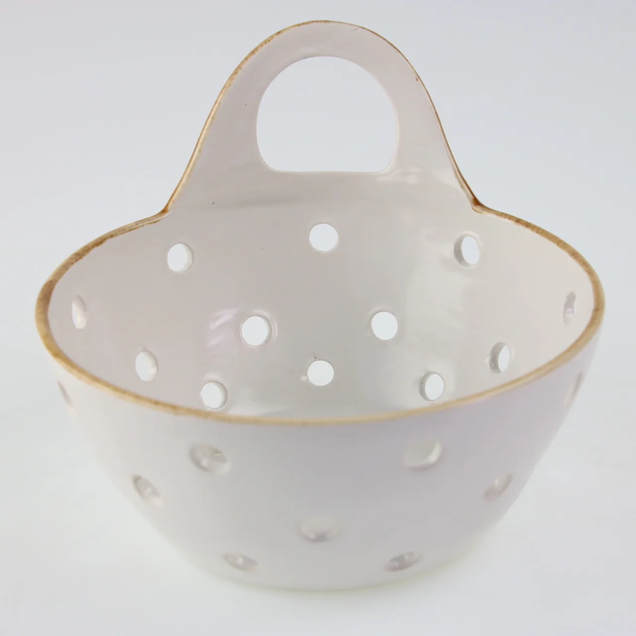 The Yara Colander Basket by Be Home is a handcrafted stoneware bowl with a handle and multiple round holes, skillfully made by women artisans and photographed against a plain white background.