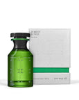 A green glass bottle of The Nue Co Forest Lungs 50ML anti-stress fragrance is displayed beside its matching white and green box, both showcasing a minimalist, modern design for natural stress relief.