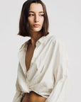 Denimist striped white TWISTED FRONT SHIRT, relaxed fit, modeled by woman with shoulder-length brown hair.