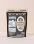 An upright package of Joon Pistachios by Faire displays the back label with nutrition facts and product details. The brown packaging with cream and white accents emphasizes these pistachios as a healthy snack choice.