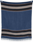 The S&A Blanket by Faire is a rectangular, vintage-inspired blue throw featuring black, white, and brown horizontal stripes near the top and bottom, finished with short fringe along the edges and shown against a white background.