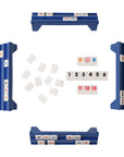 Four blue tile racks from Faire's Travel Rummy form a square, each with numbered tiles. This classic game lets you build sets in the center, making it a fun brain booster and great for family entertainment.