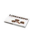 A white box of Faire LC Longhorns Milk Chocolate 6oz features images of chocolate-covered pecans, a caramel piece, and a pecan, with text highlighting the delicious milk chocolate caramel contents on the front.
