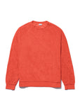 The Terry Franny sweatshirt by Kule is an oversized, long-sleeve crewneck in a vibrant solid orange, crafted from a soft, textured cotton-blend fabric and shown laid flat on a white background.