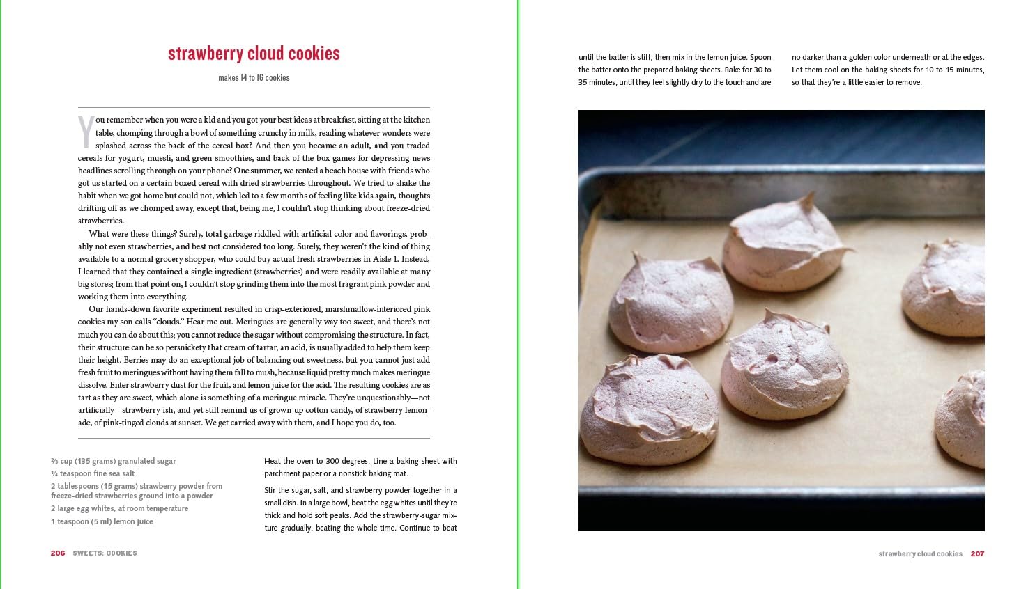 A close-up of six light pink strawberry meringue cookies with cracked tops on a parchment-lined baking sheet, alongside an easy "strawberry cloud cookies" recipe inspired by Smitten Kitchen Every Day from Random House.
