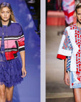 Two models showcase Paris In Fashion by Simon & Schuster Inc.: one wears a blue and red striped jacket with a ruffled dress and red clutch, the other dons a white, red, and blue patterned haute couture look with wide sleeves and short skirt.