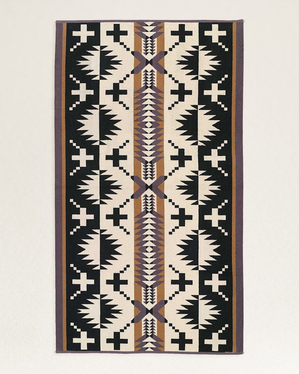 A traditional woven rug featuring a symmetrical geometric pattern with black, white, and tan colors, displayed against a neutral background in a Scottsdale Arizona bungalow by Pendleton/Babblitt's Wholesale.