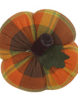 The Faire Pumpkin features orange, brown, and yellow plaid fabric, a dark brown stem, and a green felt leaf—ideal rustic fall decor or a charming farmhouse accent.