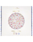 Box of Faire Mixed Set Reusable Small Plates, visible through a packaging cutout. The pastel floral pattern and scallop-shaped plates add charm, with the white box featuring gold text and floral side details.