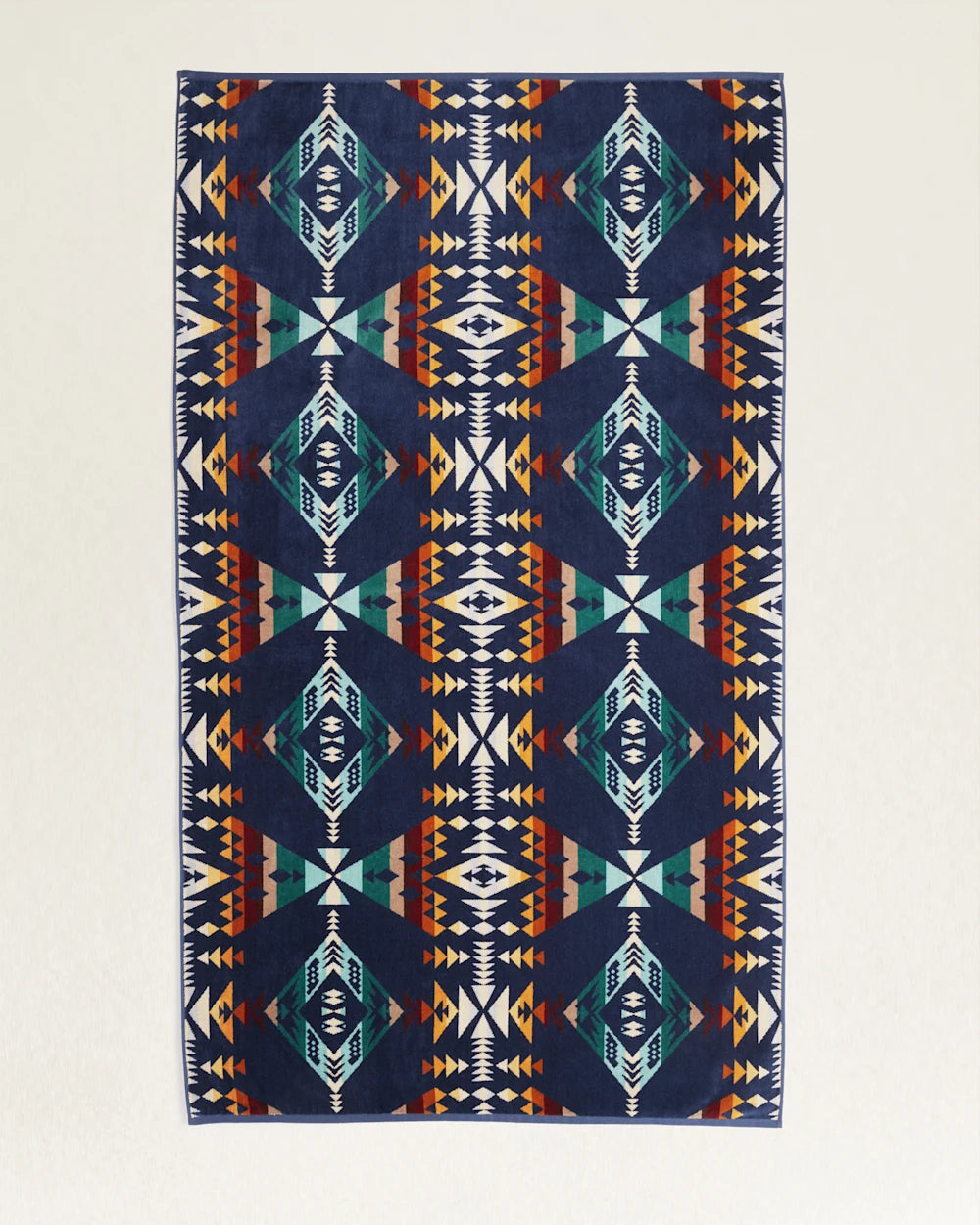 A symmetrical patterned rug featuring geometric shapes in shades of navy, orange, and white arranged in a traditional Native American-inspired design, ideal for a bungalow in Scottsdale, Arizona by Pendleton/Babblitt's Wholesale.
