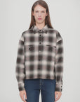 A person with straight, long brown hair is wearing the CLOSED Cropped Front OS Shirt in a black, white, and grey checkered print with chest pockets and blue jeans, standing against a plain white background.