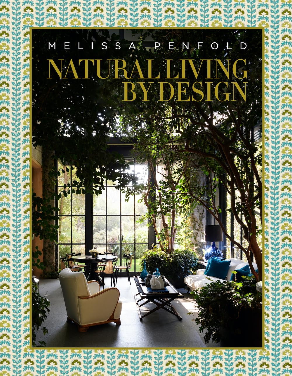 The "Natural Living by Design" book cover from Hachette Book Group features a plant-filled room with natural materials, large windows, cozy seating, soft light, and a blue and yellow patterned border.