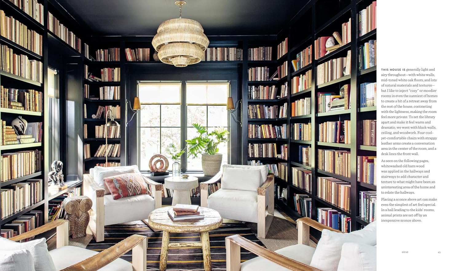 A cozy home library inspired by Hachette Book Group’s "Down to Earth," with floor-to-ceiling bookshelves on dark walls, sunlight from large windows, four white armchairs, a rustic wood table, and a woven chandelier.