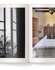 An open book, "Creating A New Home In Mallorca" by Ingram Book Company, displays a black-and-white photo of a window view with trees on the left page and a color photo of a neat bed in a Mallorca renovation on the right.