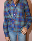 Blue plaid Cissa The Daily Shirt styled with light blue jeans, set against a pink background for a modern look.