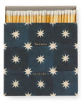 Faire's Matches/Square features an open box of white-tipped matches with a dark blue cover adorned with white stars and "luxury matches" in gold—an eye-catching example of matchbox design.