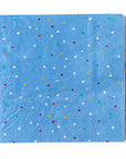 The Faire MME Napkin is a blue paper napkin with red, white, yellow, and green polka dots and a textured border, neatly folded into a square—ideal for festive gatherings or as cheerful holiday dinner decor.