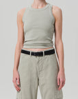 A person wears a light gray Isabel Rib Tank by Citizens Of Humanity/AGOLDE with high-waisted, light olive green pants and a black belt. Their arms are relaxed by their sides against a plain gray background. This versatile tank is perfect for layering with any outfit.