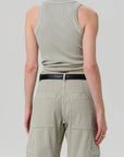 A person wears the Isabel Rib Tank by Citizens Of Humanity/AGOLDE, a light gray organic cotton racerback tank top. They pair it with light khaki cargo pants and a black belt. Facing away, arms relaxed, they stand against a plain white background.