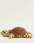 Faire’s Turtle Warmies is a plush turtle toy with a soft brown shell and yellow-and-white patterned limbs and head, providing sensory comfort as it rests on a plain light background.