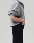 Heather grey Mirelle Funnel Feck sweater by Citizens Of Humanity/AGOLDE, styled with one hand in pocket, side view.