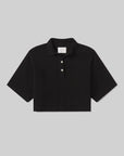 The Lowen polo shirt by Citizens Of Humanity/AGOLDE is a black cropped Supima jersey top with short sleeves, a collar, and three white buttons on the placket, shown against a light gray background.