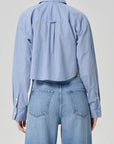 A person wearing light blue jeans and the ana cropped shirt in banker blue plaid by Citizens Of Humanity/AGOLDE, shown from the back against a plain light gray background.