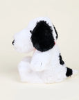 The Snoopy / Red Collar Warmies by Warmies/Intelex is a microwavable plush dog toy in black and white, with floppy black ears, a black nose, and short tail, offering gentle sensory comfort against an off-white background.