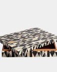 The Calisson Diamond Box L by Global Views is a rectangular MDF decorative box with a black, white, and gray geometric triangular pattern. Its slightly open lid reveals a brown interior, standing out against a plain white background.