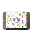 The Tattly Tattoo Tin by Faire is a reusable rectangular slide-top tin featuring colorful plant, flower, and mushroom designs. Inside, you'll find 10 Tattly Temporary Tattoos and an application sponge.