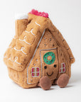 The Amuseables Gingerbread House by Jelly Cat Inc. is a plush toy with stitched decorations, a smiling face on the door, and two soft brown feet, shown against a plain white background.