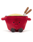 Jelly Cat Inc.’s Amuseables Cheese Fondue is a plush toy shaped like a fondue pot with a smiling face, tiny arms, black feet, fluffy yellow “cheese,” and two plush brown sticks—great for fun Swiss-themed gatherings or gifting.