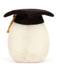 The Amuseables Boiled Egg Graduation by Jelly Cat Inc. is a plush toy shaped like a boiled egg, featuring soft fur and wearing a black cotton mortarboard with a gold tassel, set against a plain white background.