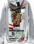 The Backpack Homestud Bleachout Hoodie by Free City (sparrow, LLC) is a gray hoodie with studded hood, colorful "california kid," FREECITY DOVE, “MAKE A BACKPACK,” and backpack graphic on the back.