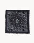 Black cashmere scarf with white paisley print and frayed edges by KUJTEN, shown flat on a white background.