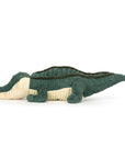 The Allexi Alligator by Jelly Cat Inc. is a soft, green and beige plush toy with textured fabric, shown lying on its stomach in a side profile—a cute tribute to meat-free Southern food on a plain white background.