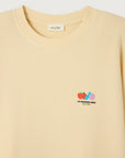 A light yellow crewneck t-shirt by American Vintage with a small colorful "LA MAISON AMV since 2005" logo on the left chest—ideal for layering under your favorite Atubay Sweatshirt.