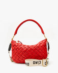 The Clare Vivier Crossbody Strap S25 is a red woven handbag with a curved handle and gold hardware. It includes a detachable, adjustable white strap made of durable cotton webbing, featuring "CIAO" in black. Displayed against a plain white background, it oozes style and versatility.