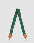 The Clare Vivier Adjustable Crossbody Strap features green cotton webbing, tan leather trim on the ends, and gold metal clips, shown laid flat on a white background.