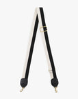 The Clare Vivier Crossbody Strap S24 features black and white nylon webbing, gold-tone hardware, black leather trim, and metal clips for easy bag attachment.