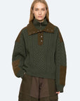 Green cable half zip sweater by Sea New York styled with cargo pants, shown against a plain backdrop.