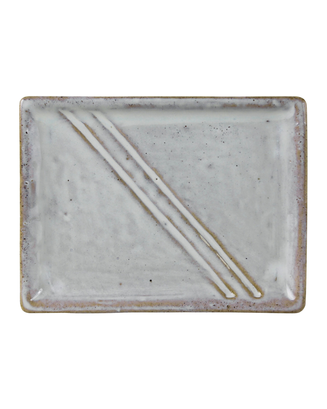 A rectangular Delta Tray Ceramic plate with a speckled finish and two thin, delicate HomArt chopsticks resting diagonally across it, isolated on a white background in Scottsdale, Arizona.