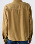 A person shown from the back wears the AMO Denim Jenn Shirt in light brown corduroy with blue jeans, set against a plain, light background.