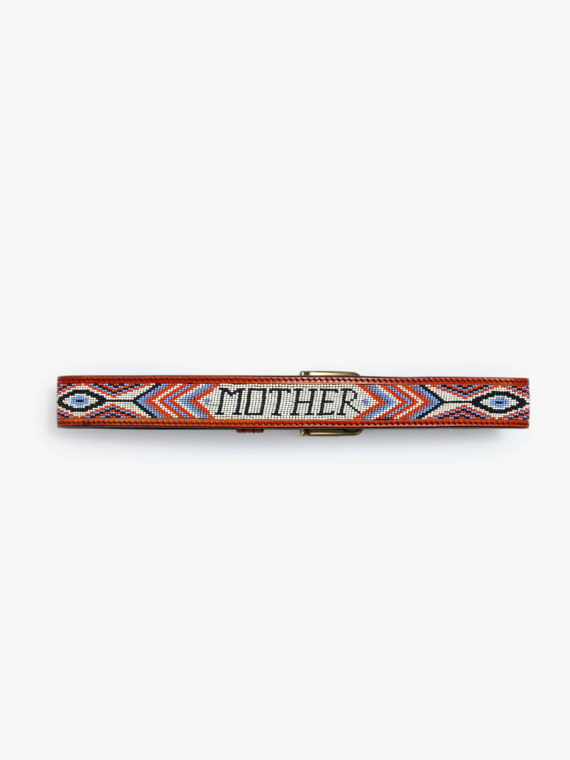 The Eye Opener by Mother is a colorful beaded leather belt with red, orange, blue, black, and white geometric patterns and "MOMINE" spelled in white beads at the center.