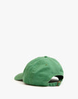The Clare Vivier "Baseball Hat PasMal" is a green 100% cotton cap shown from the back, featuring visible stitching, a curved brim, and an adjustable sliding metal closure against a plain white background.