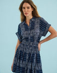 Blue Howard Dress by Hunter Bell NYC, styled on model with hand on hip, light blue background.